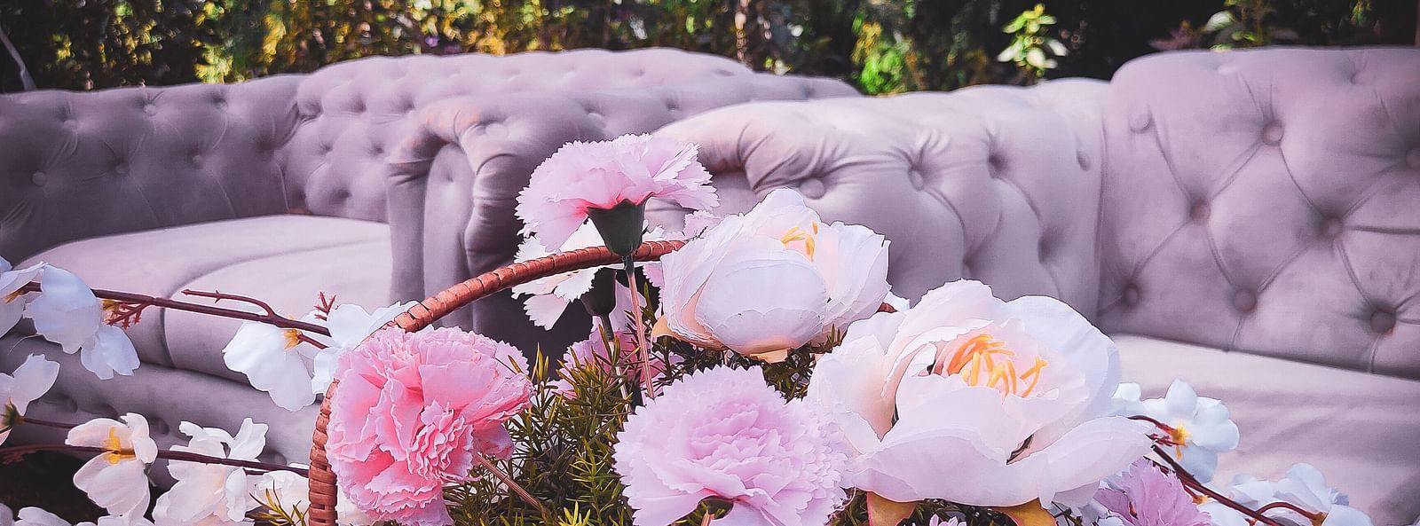 Seating with couches, flowers, and decorative lighting.