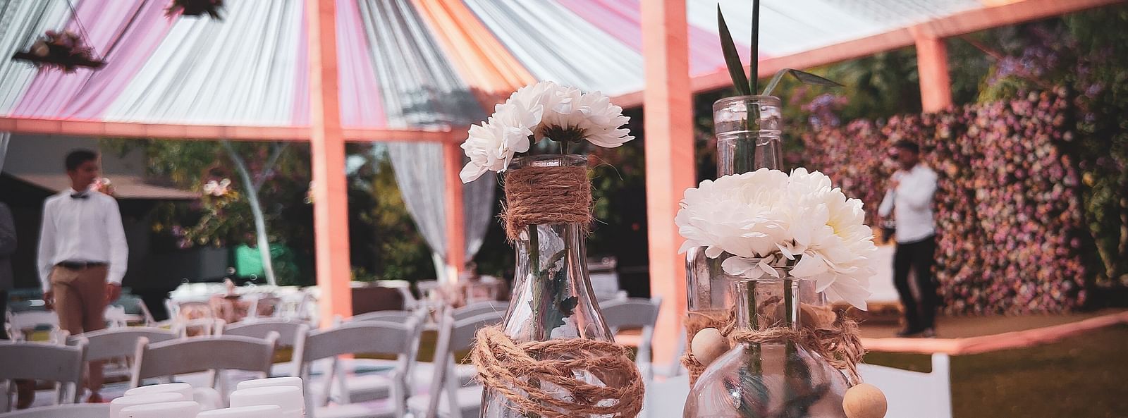 Tent with fabric ceiling, hanging lights, and tree trunk table.