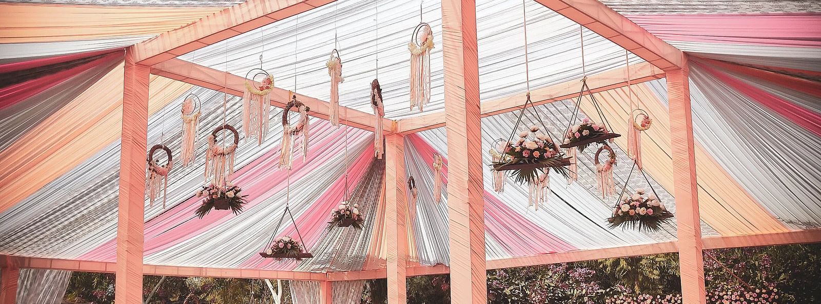 Outdoor event tent with colourful draped fabric ceiling, supported by a frame. - Bamboo Saa, Udaipur