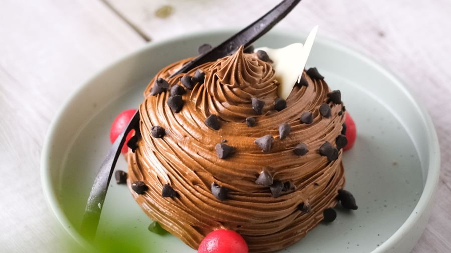 Chocolate pastry with a cherry on a grey plate | Mango Hill, Pondicherry
