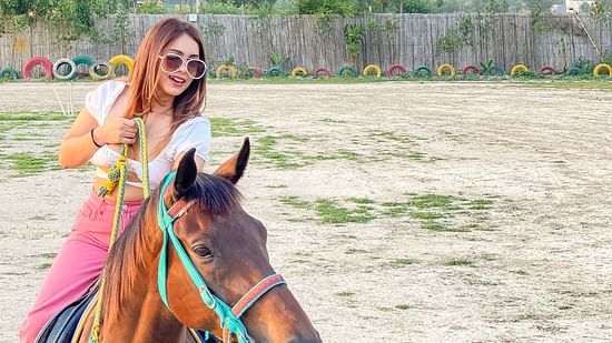 A girl riding a house that is available to rent at Themis Mudhouse - Themis Mudhouse - A Nature's Retreat Resort & Wellness