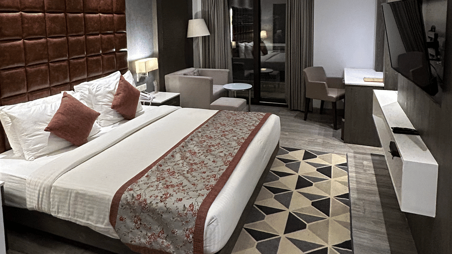 A bedroom featuring a double bed with a patterned runner, a geometric rug, and a ceiling fan | Sand Heaven