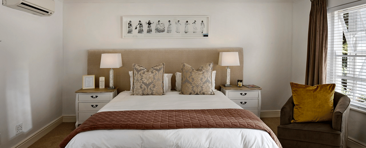 A double bed with a ceiling fan hanging over it in a bedroom.