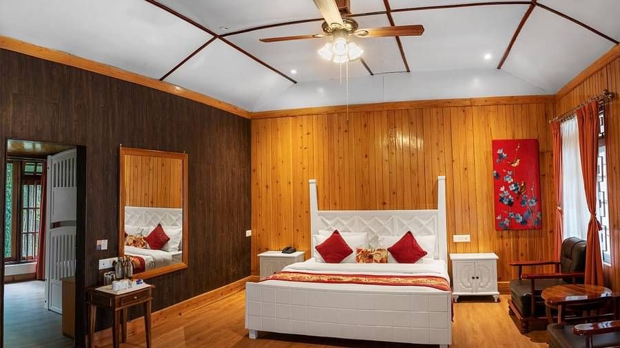 A room at Summit Barsana Resort & Spa, Kalimpong with a double bed and large windows
