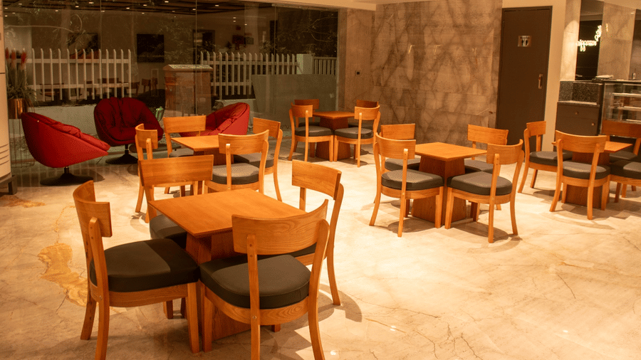 Indoor restaurant seating area with tables, chairs, and ceiling lights arranged in a grid pattern.