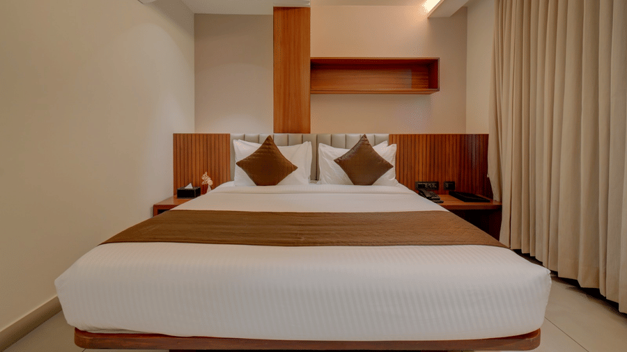 The suite bedroom at Hari Govindas, Siddappa Square, featuring a bed with a window on the side.