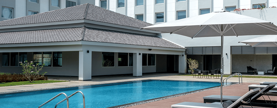 exterior of The Residency Towers Rameswaram with a swimming pool in front of it