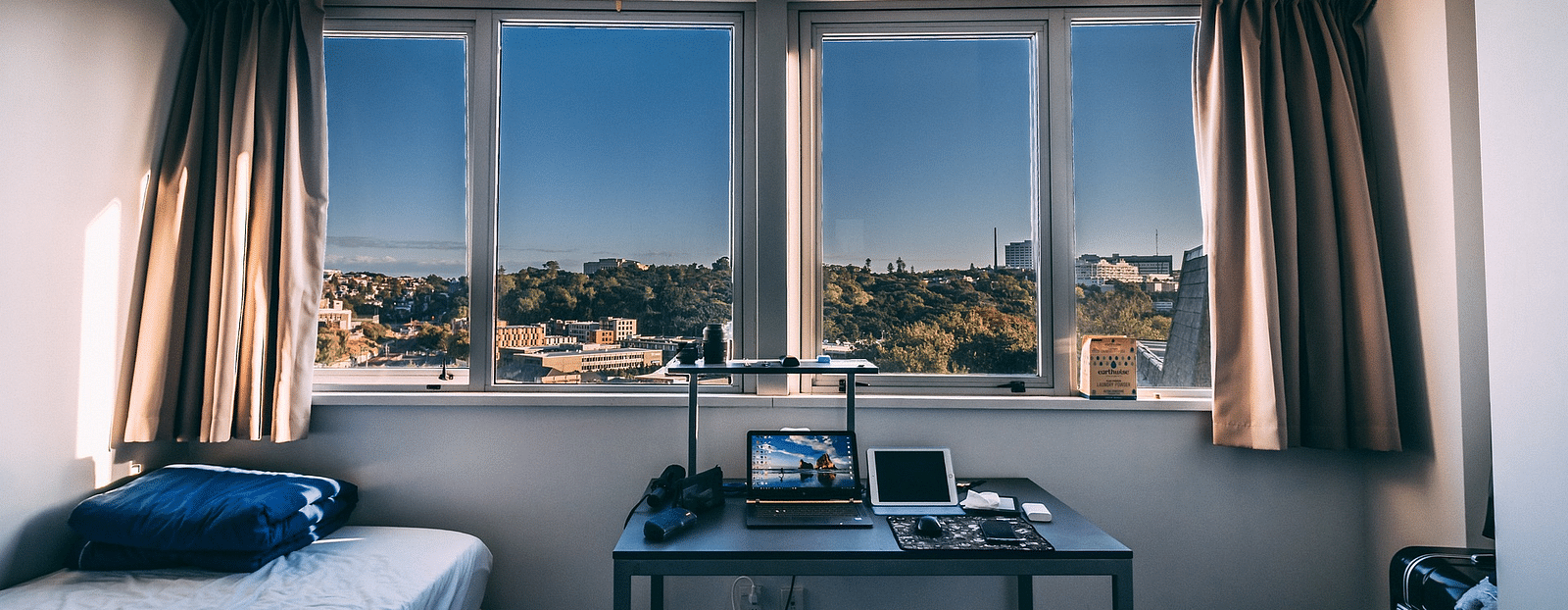 A room with a comfortable bed with a view of the senery