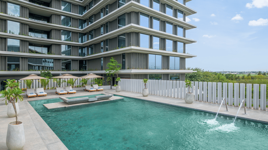 Rooftop swimming pool with loungers and a view of the building against the sky at The Residency Signature Madurai.