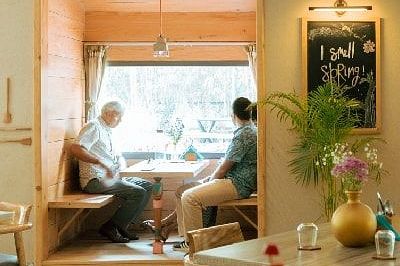 Woman sitting at a cafe style indoor seating area at Karma Chalets.