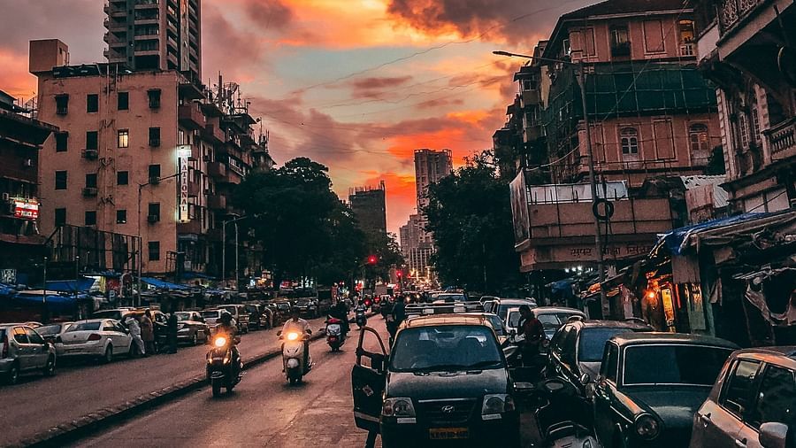 an image of a street in the evening featuring vehicles and building