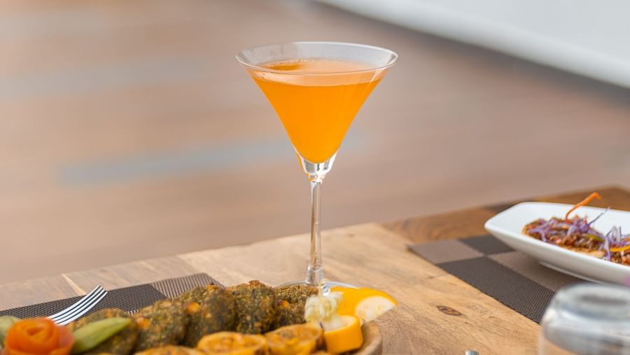Beverage served in martini glass next to a platter of starters at The Bridge restaurant at Clarks Inn Suites Jaipur