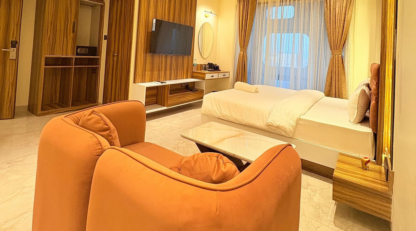 A shot taken from behind the sofa, showcasing the spacious room at Hotel Mumbai House, Vashi.
