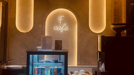 Front view of the F Cafe featuring a mini fridge with transparent door at F Hotels, Bengaluru.