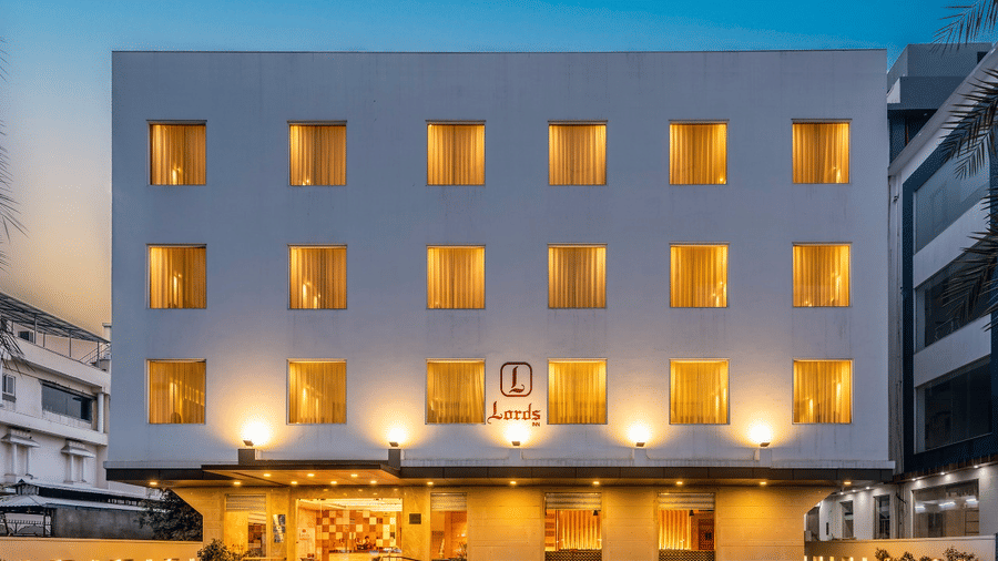 Front view of a modern hotel building lit warmly at dusk.