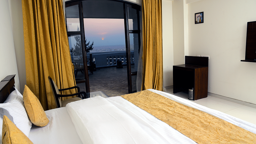 A bedroom with a large balcony that opens to a picturesque view - VITS ExcellenSea, Dapoli