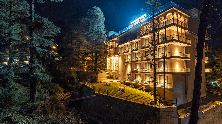an image of long shot view of Mastiff Select Mandavya Dharamkot, McLeodganj at night illuminating yellow 