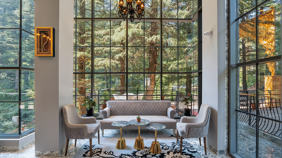 an image of a lobby area covered by glass with hill view at Mastiff Select Mandavya Dharamkot, McLeodganj