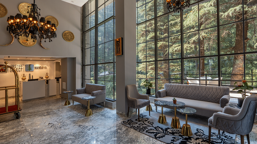 an image of a lobby area with seating arrangements and antique chandeliers 