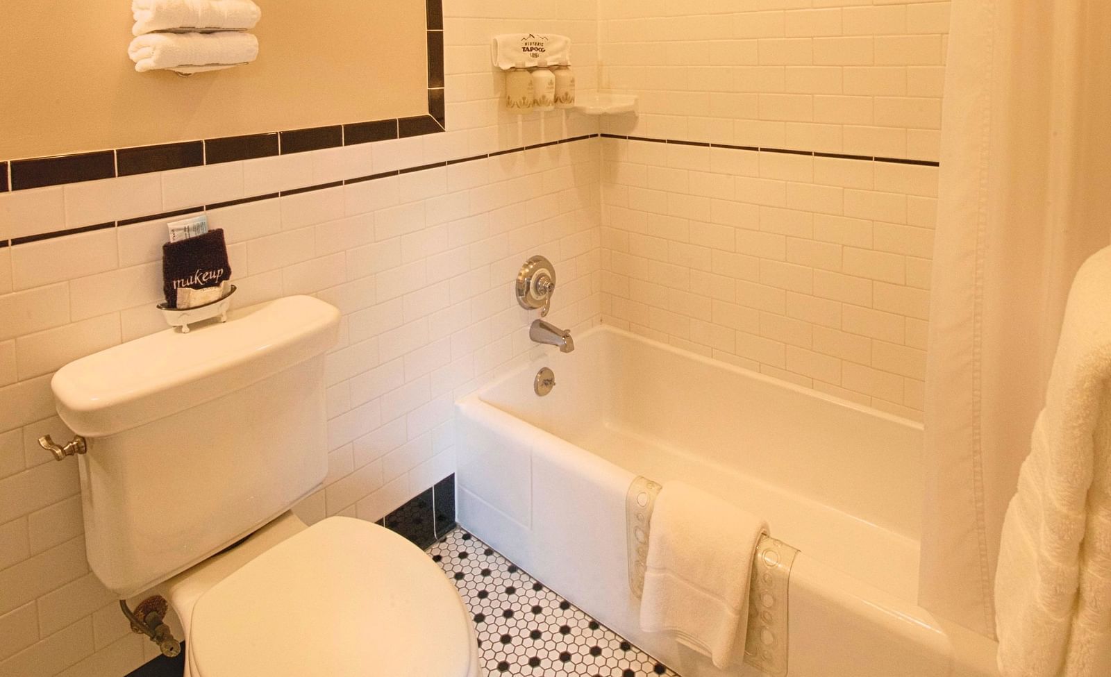 a bathtub with curtains and a commode besides it in a bathroom - Historic Tapoco Lodge