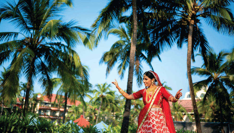 a bride posing for a picture with coconut trees in the background - Caravela Beach Resort Goa
