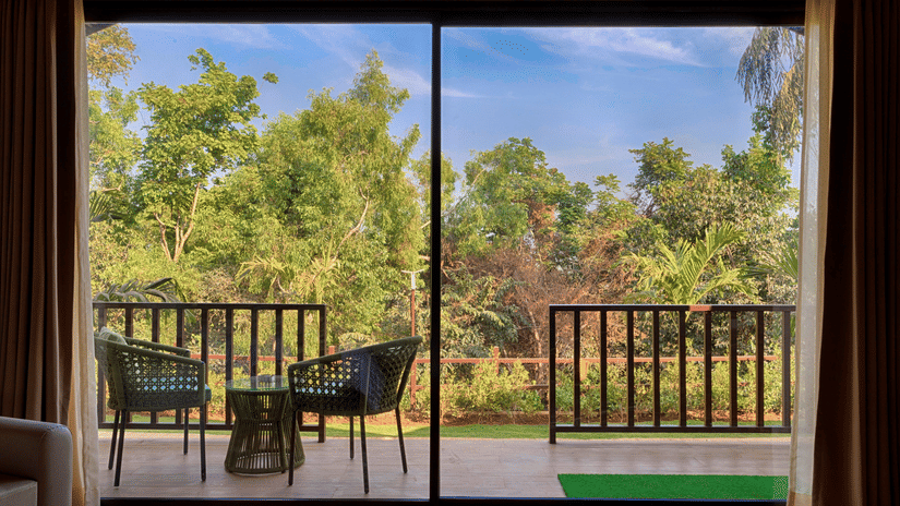 A stunning view of lush greenery from the private balcony of the Premium Cottage at Stone Wood Premier Gokarna.