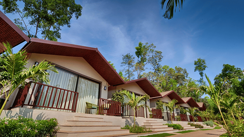 A bright daytime view of the Premium Cottage with a well-maintained pathway and tropical landscaping.