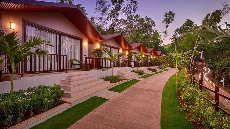 A twilight view of the Premium Cottage with soft ambient lighting, tropical plants, and a serene atmosphere.