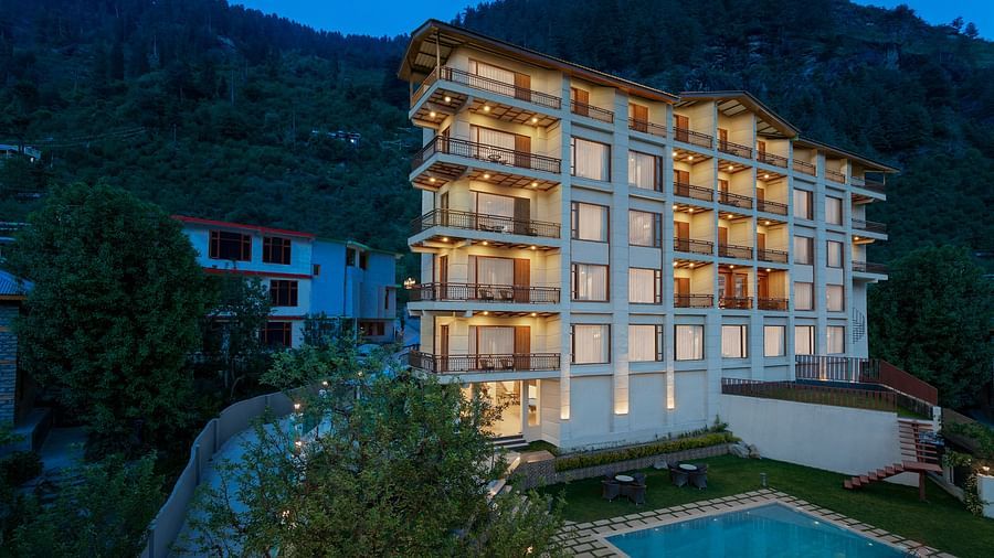 Exterior facade view in the night with the lights on of The Orchid Hotel in Manali.