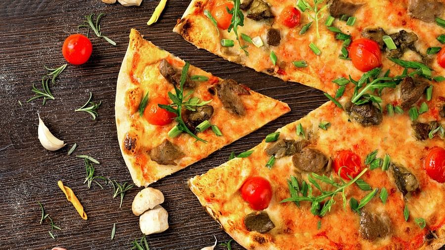 a view of a pizza from a top with a small slice moved away from the pizza