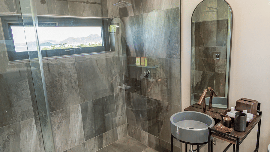 A bathroom with a sink, glass shower, and a mirror at Tamarind Hills Resort and Villas, Antigua