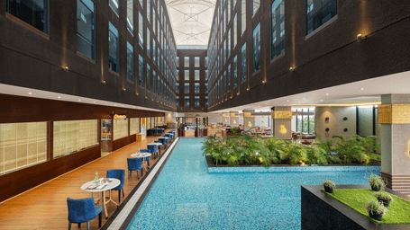 Blue Salt Cafe at Essentia Luxury Hotel near World Cup Square, Indore, featuring poolside seating and the narrow facade.