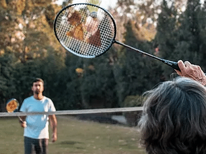 Two children playing badminton in an open area at Karma Chalets.