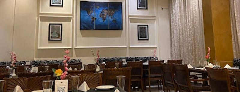 Full view shot of the Gold Plate restaurant with several photo frames wall mounted behind the dining tablesCorner view shot of the dining area of the Gold Plate restaurant with central air-conditioning and a small cabinet in the corner of the restaurant - 
