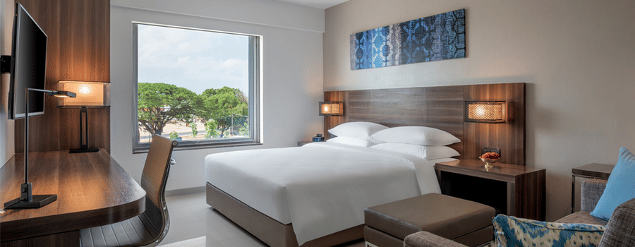 Standard king room featuring a bed, couch, television and a working area at The Residency Towers Rameswaram