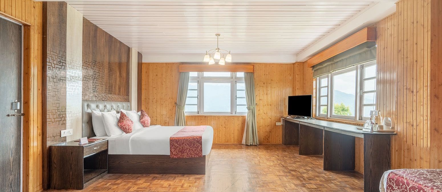 Side view of a room with bed and wooden wall decor at Summit Tashi Ghang Heritage Resort, Pelling