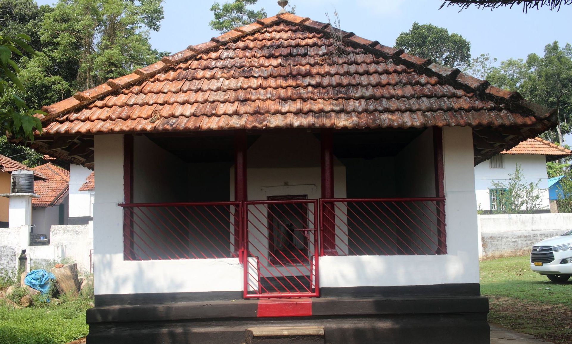 Kaimada shrine with red steps and tiled roof in Kodagu.