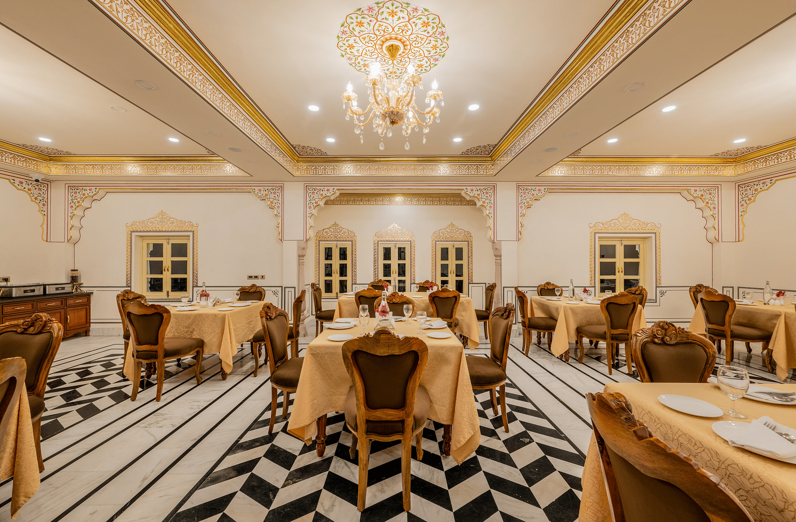 full view image of our multi-cuisine restaurant with an elegant chandelier hanging from the top - Brij Castle, Jaipur