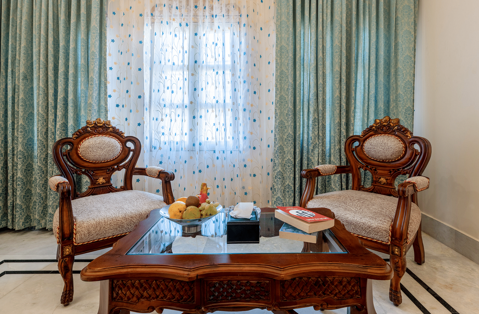 a close up image of a common seating area with two cushioned armchairs - Brij Castle, Jaipur