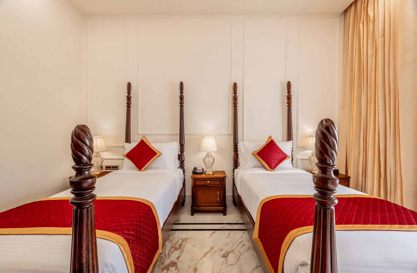 front view image of the twin bed with a bed side table in the middle with beige coloured curtains in the side - Brij Castle, Jaipur