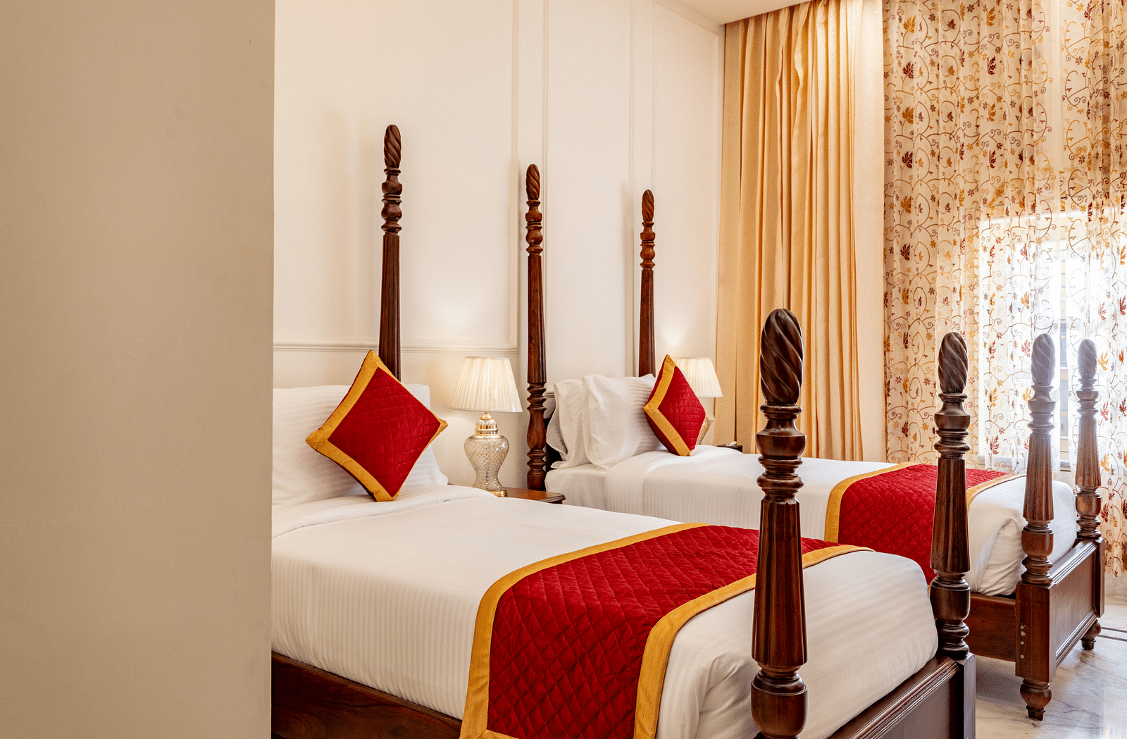 a bedroom with two single beds with plenty of natural light coming from the window beside it - Brij Castle, Jaipur