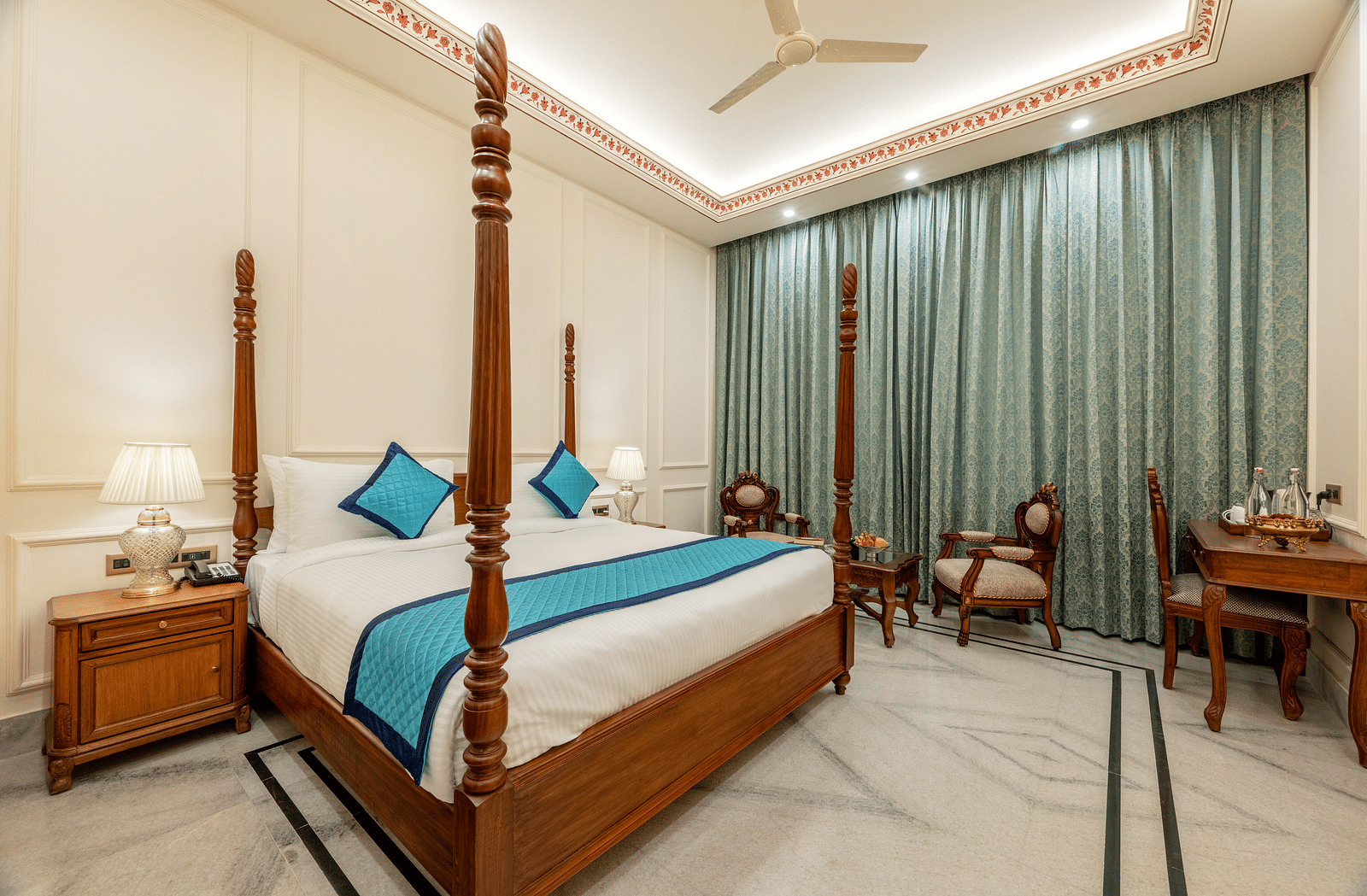full view image of the room featuring a double bed along with a common seating area at the far end of the room - Brij Castle, Jaipur