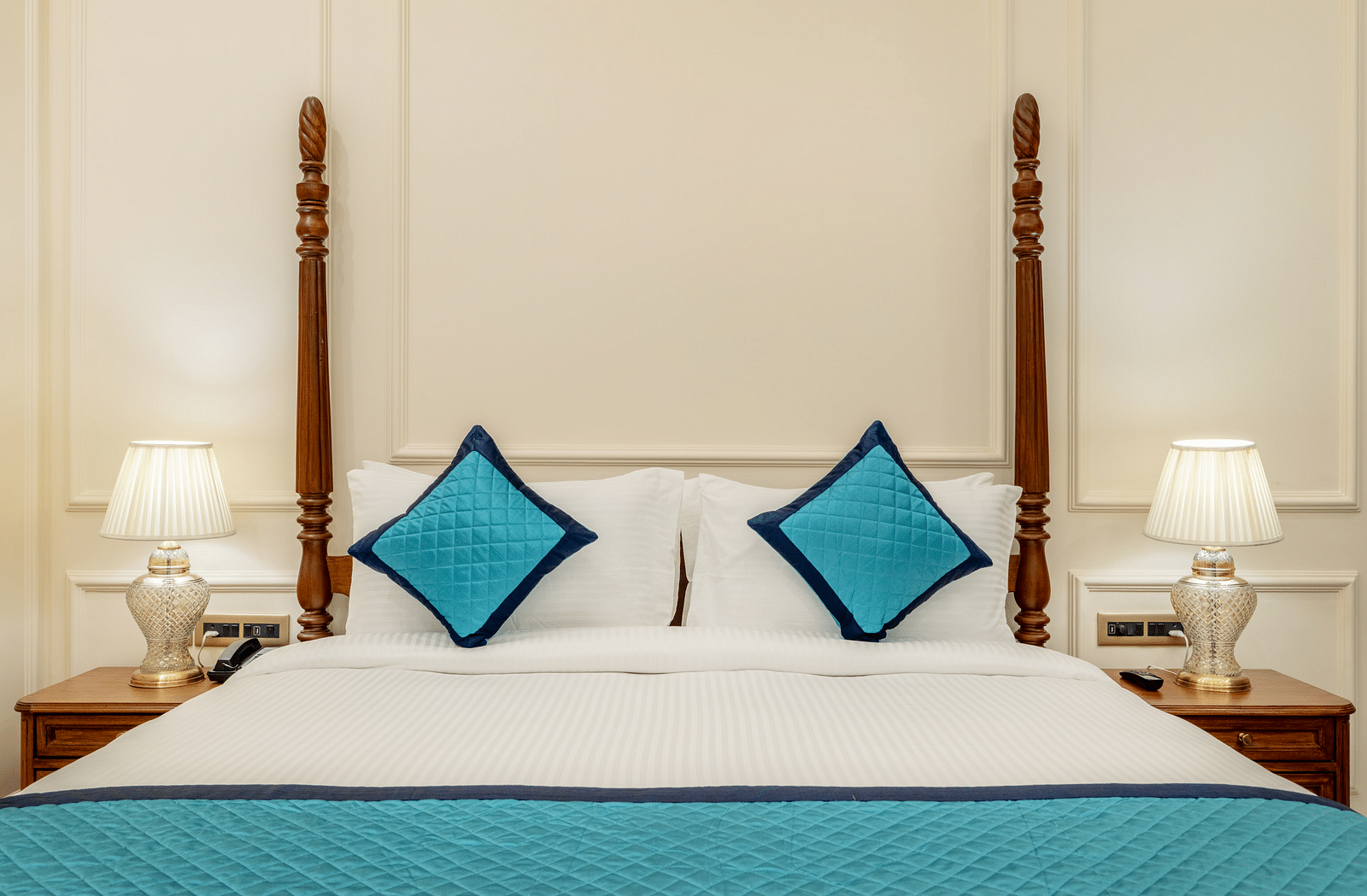 a close up image of the king size bed with two bed side lamps on either side of it - Brij Castle, Jaipur