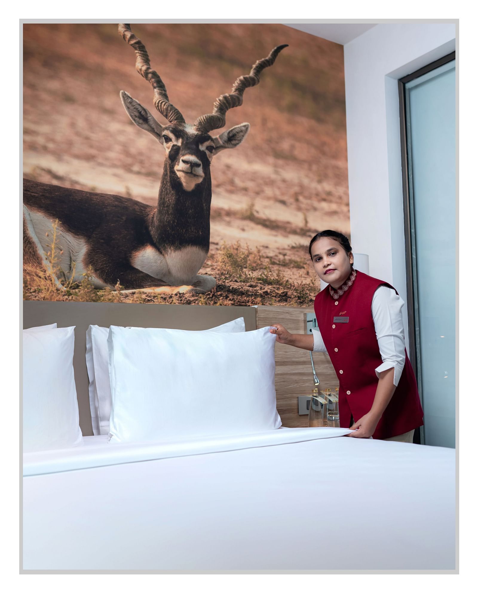 A photo of Ms. Anusha near a bed. 