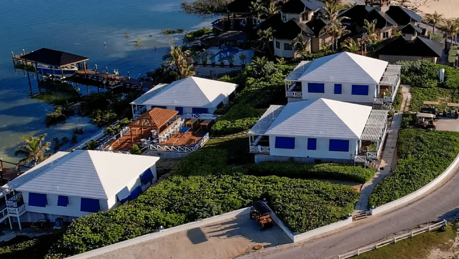 Aerial view of coastal houses near the beach, including green lawns and palm-lined pathways | Abaco Inn