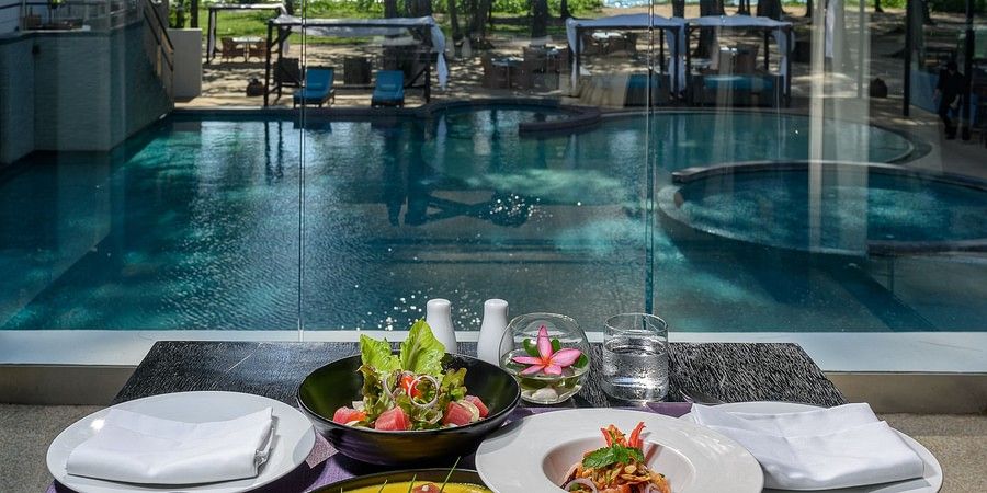 alt-text image of exotic food served with white porcelain plates served at the poolside - Maikhao Dream Villa Resort & Spa, Phuket