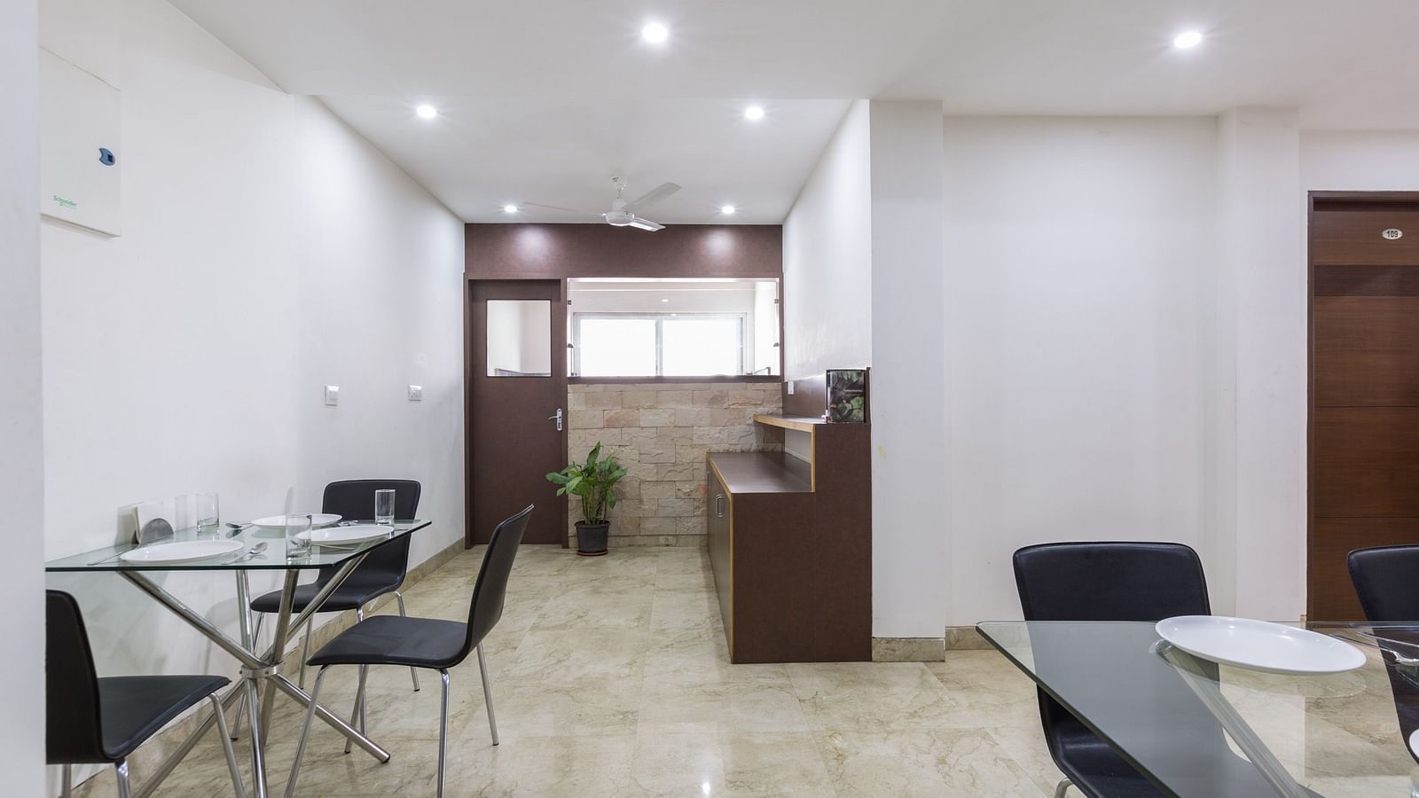 A dining area with small tables and chairs - Sanctum Suites BEL Road, Bangalore