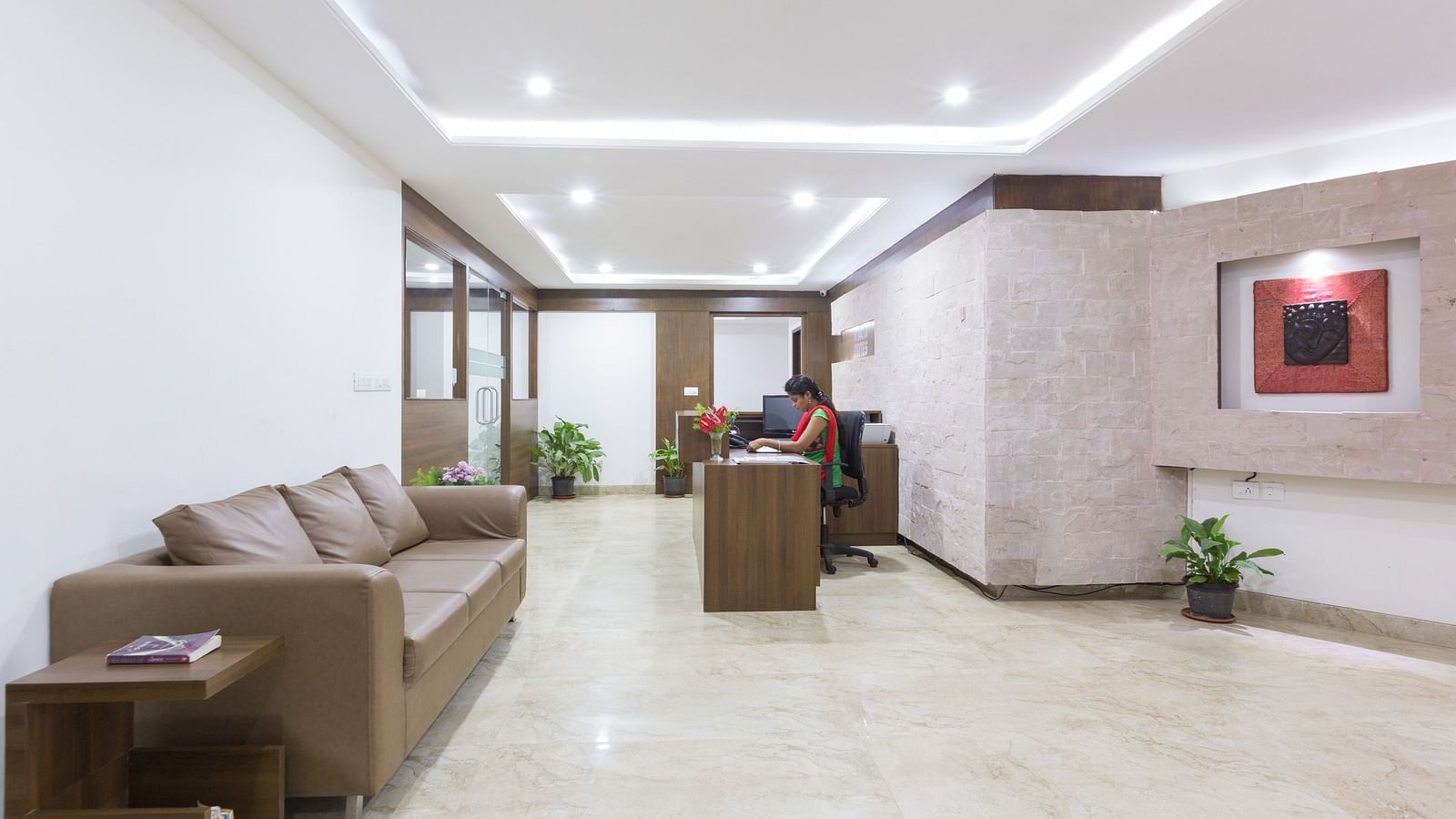 A lobby area with cushioned sofas, a coffee table, and decorative lighting on the ceiling - Sanctum Suites BEL Road, Bangalore
