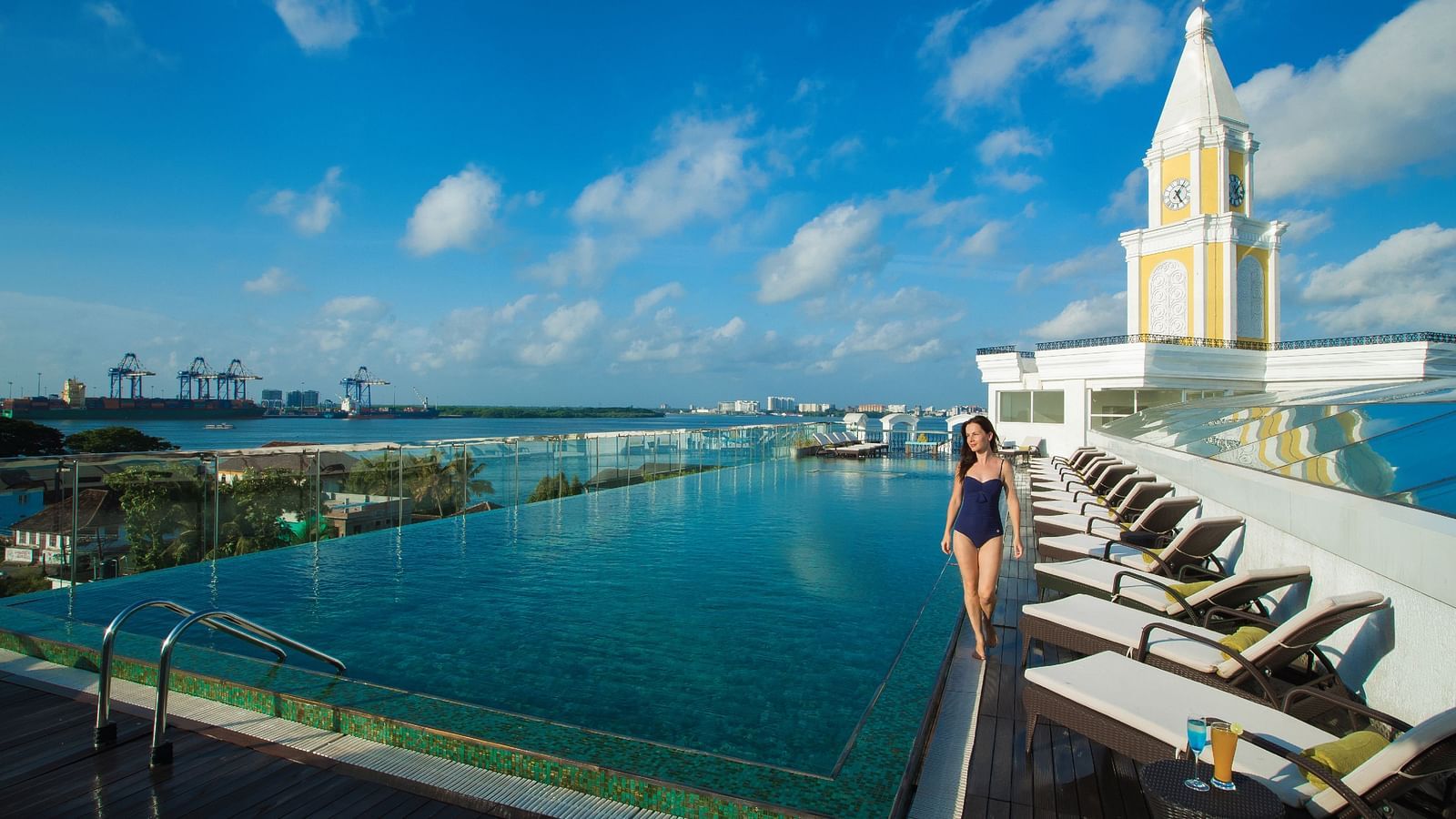Swimming pool adjacent to the building, with decorative tiled borders around the water