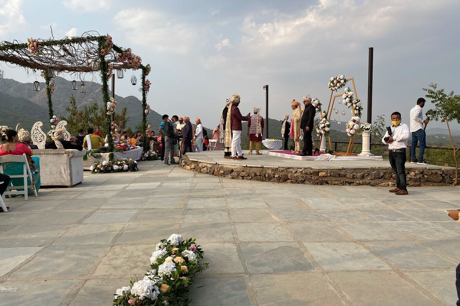 An outdoor event space with people standing on a stone floor.